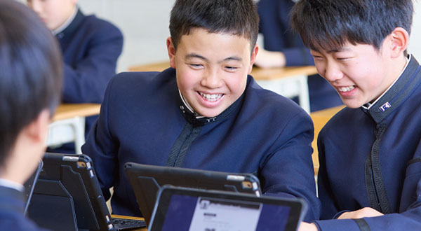 iPadを一緒に眺めている生徒たち