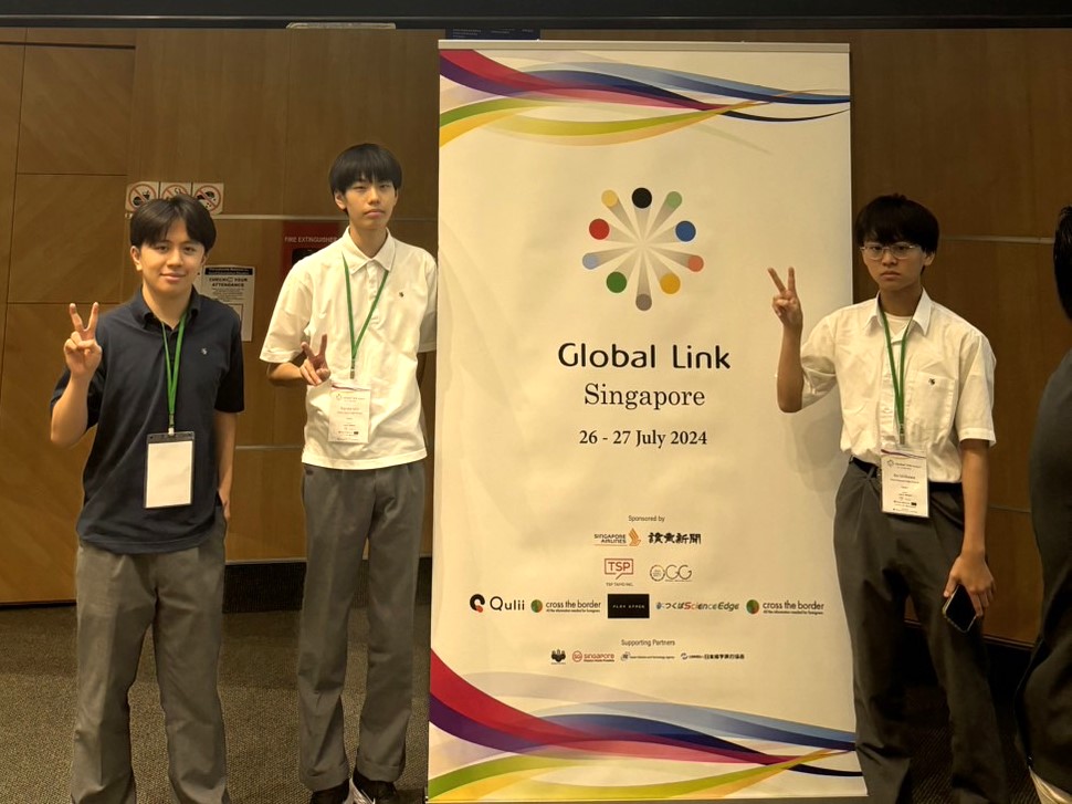 Global Link Singapore 2024ポスター前でピースする生徒たち