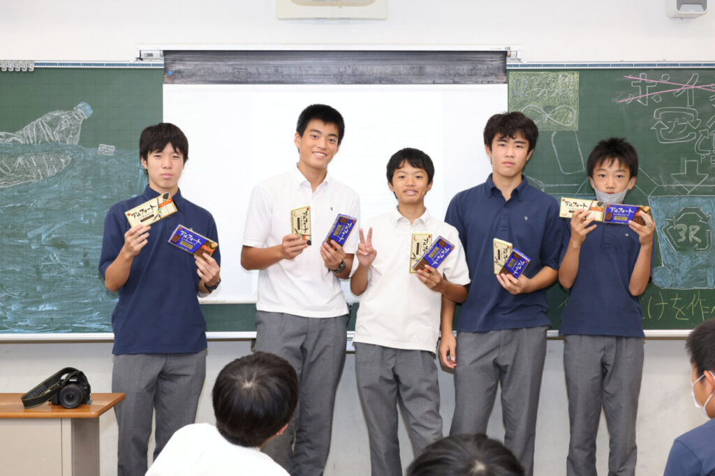 渦潮祭で黒板の前でアルフォートを持った生徒たち